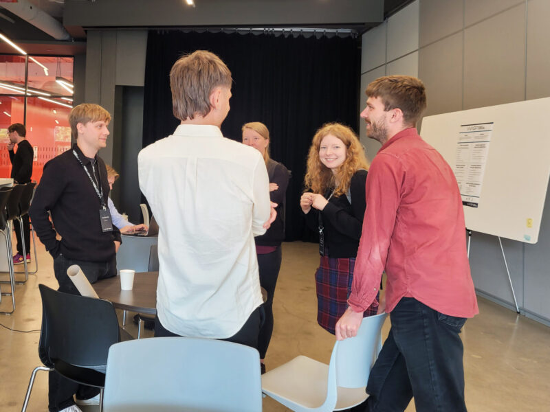 Five WASP PhD students talking to each other.